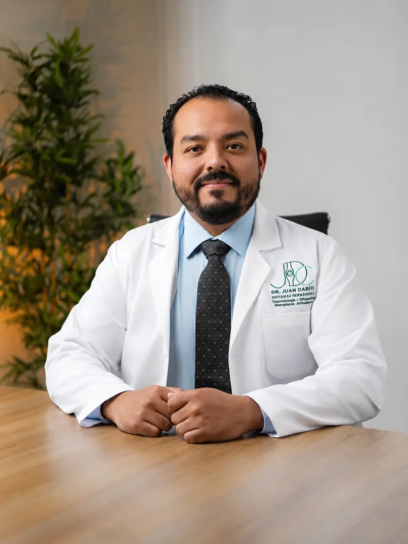 Dr. Juan Darío Cortinas en su consultorio Dr. Juan Darío Cortinas sentado en su consultorio con bata médica